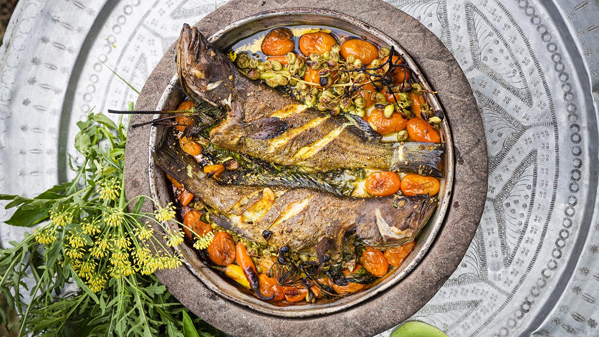 Oven-Baked Fish with Grapes & Tomatoes. Erez roasts fish in a traditional Taboon oven with tomatoes, chilis, habaneros, garlic gloves, sour grapes, and the requisite bath of olive oil and salt.