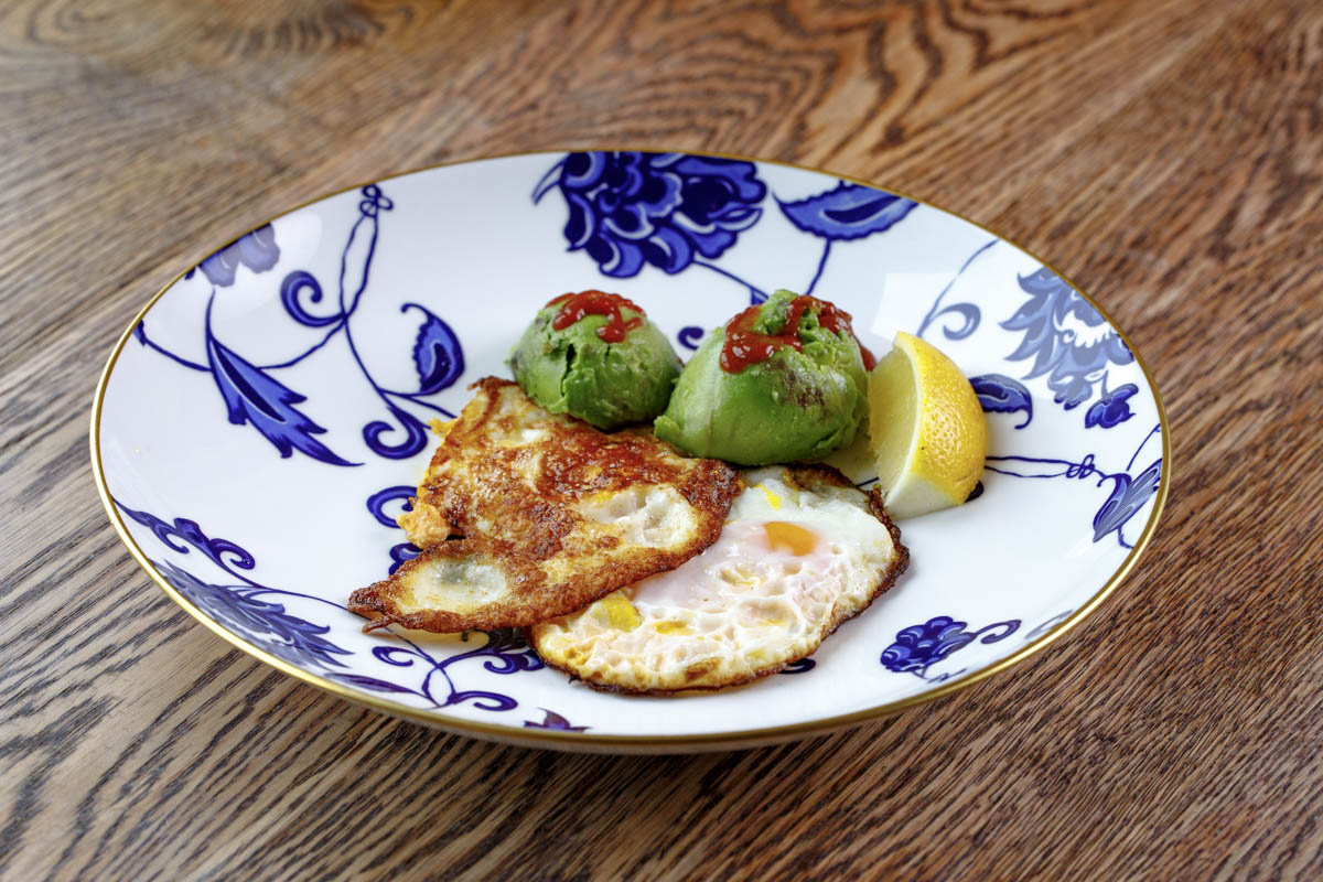 Classic Fried Eggs. When it comes to fried eggs, he likes to serve them elegantly in butter and fry them until crispy. The crispy fried eggs are then served with angelic avocado and devilish sriracha to give the dish some balance and contrast.