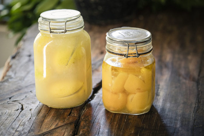 2 contrasting jars of preserved lemons before and after the lemons are preserved.