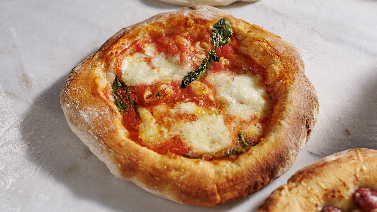 Pizza Margherita. A guaranteed crowd-pleaser. Grate a handful of cherry tomatoes and top with mozzarella, basil, and olive oil for this classic pizza.